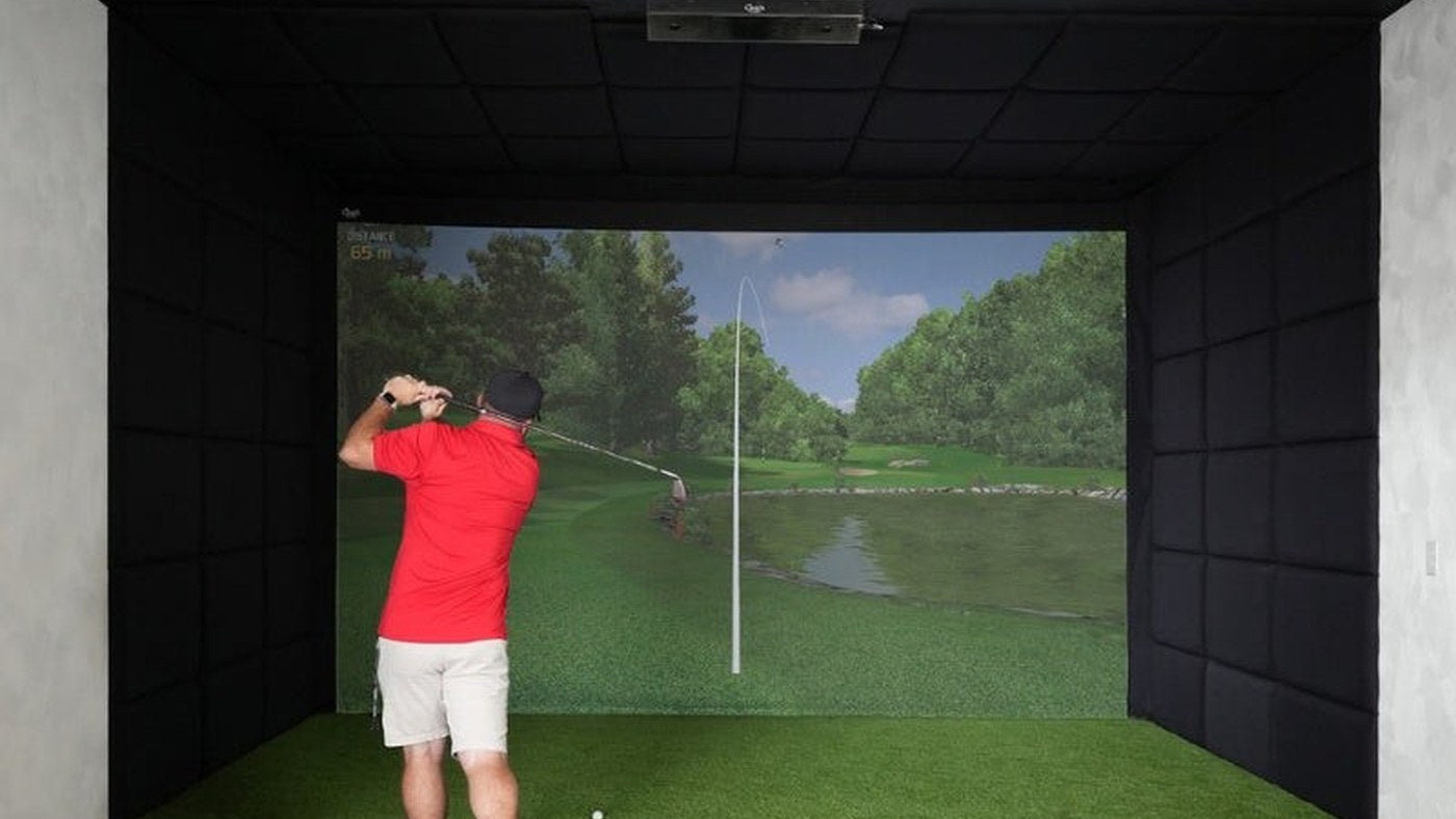 Golfer using a home simulator with an enclosure and impact screen