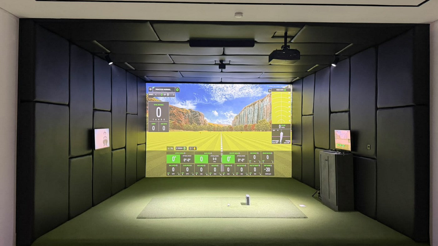 SkyTrak golf simulator room with a ceiling-mounted BenQ projector, padded walls and an impact screen