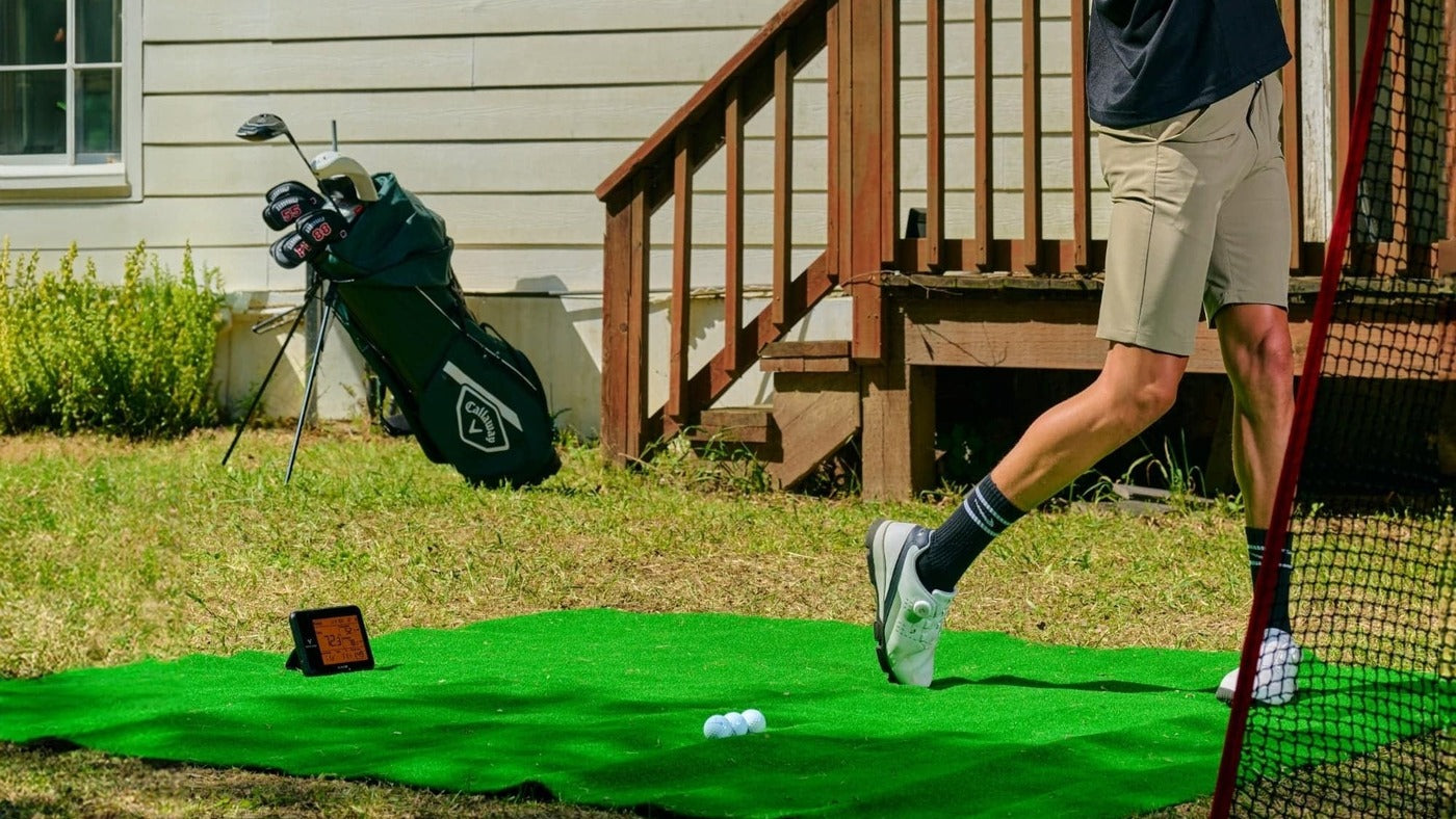 Swing Caddie SC300i on a hitting mat during outdoor golf practice