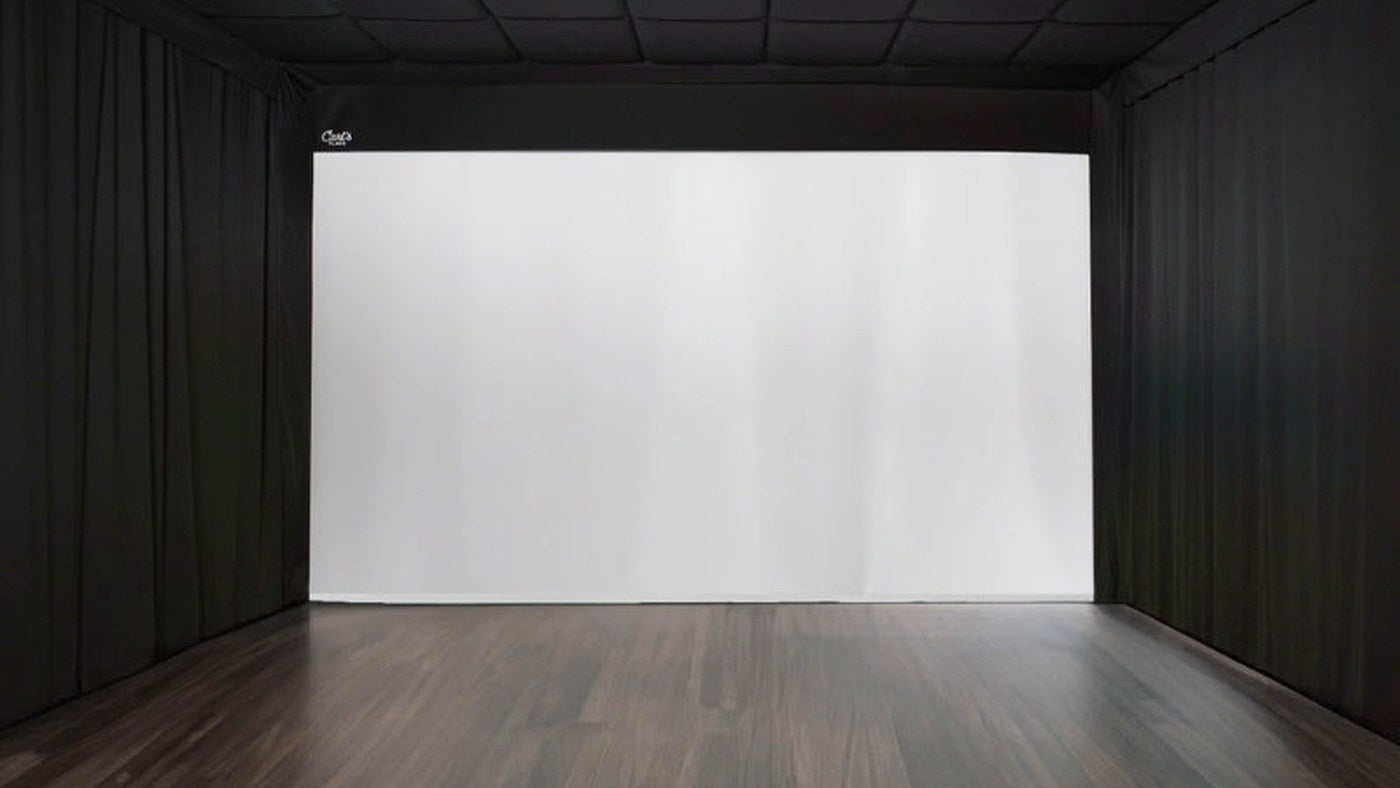 Built-in golf impact screen with dark padded walls and ceiling.