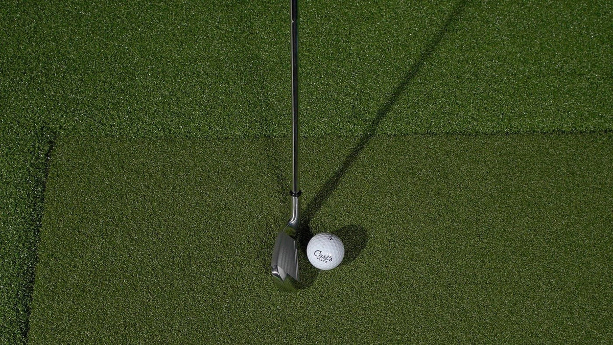 Golf ball and club on a Carl’s Place HotShot hitting insert