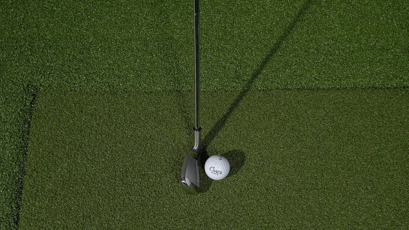 Golf ball and club on a Carl’s Place HotShot hitting insert