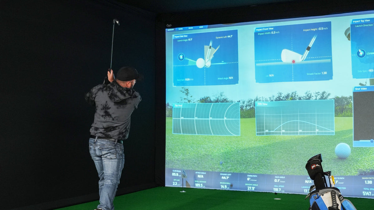 Carl's Place golf simulator enclosure in an indoor golf setup.
