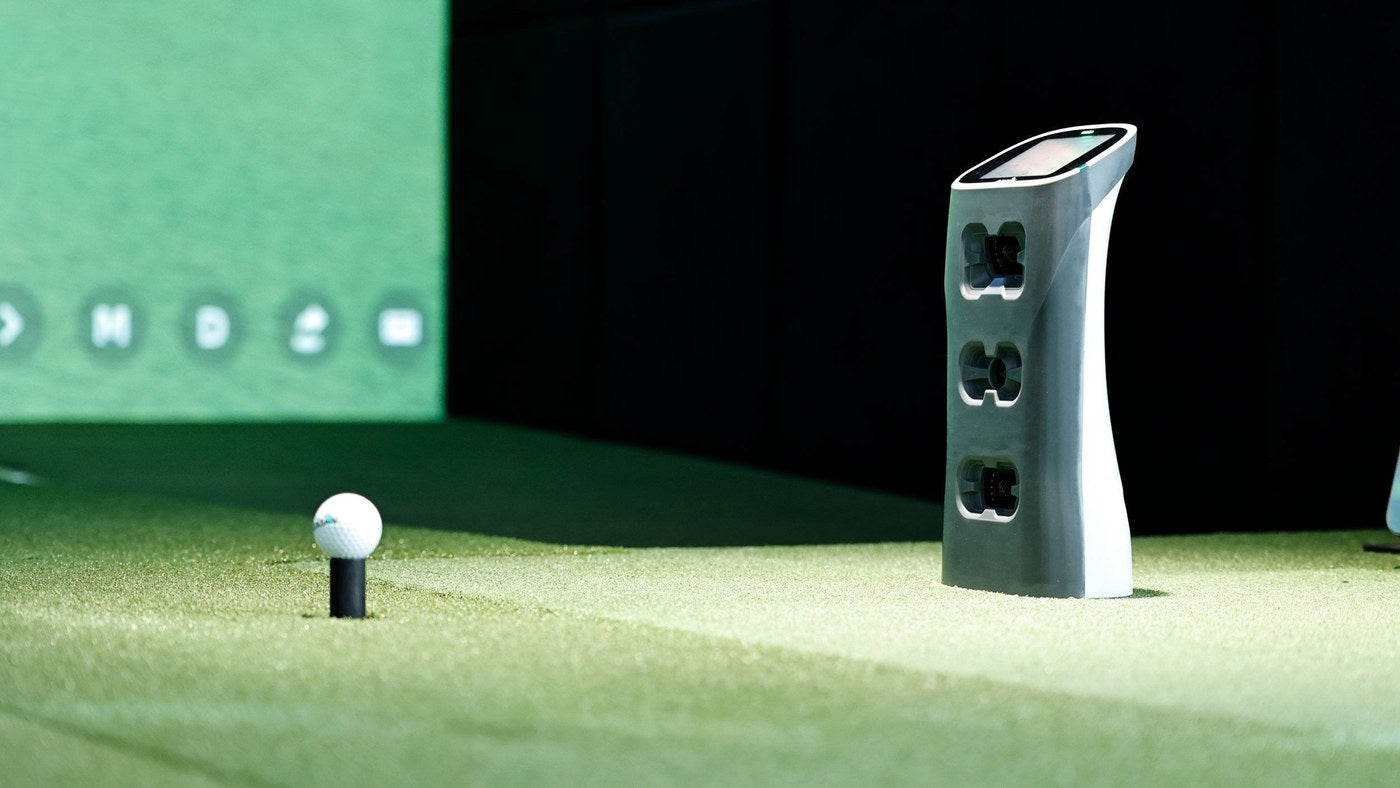 GOLFJOY Spica 3 portable launch monitor positioned beside the golf ball