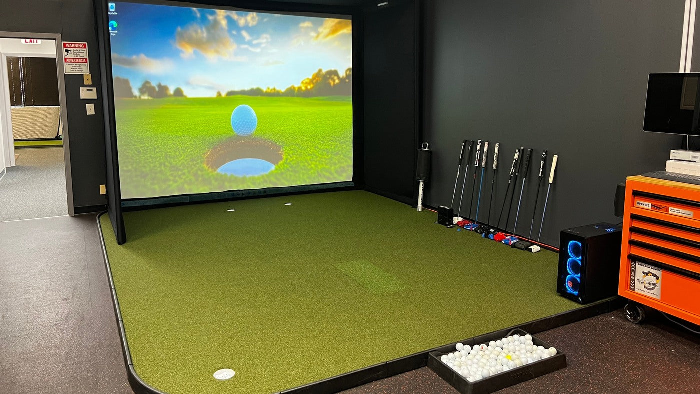 SIGPRO Flooring with putting cups and an integrated hitting area in a finished golf simulator room.