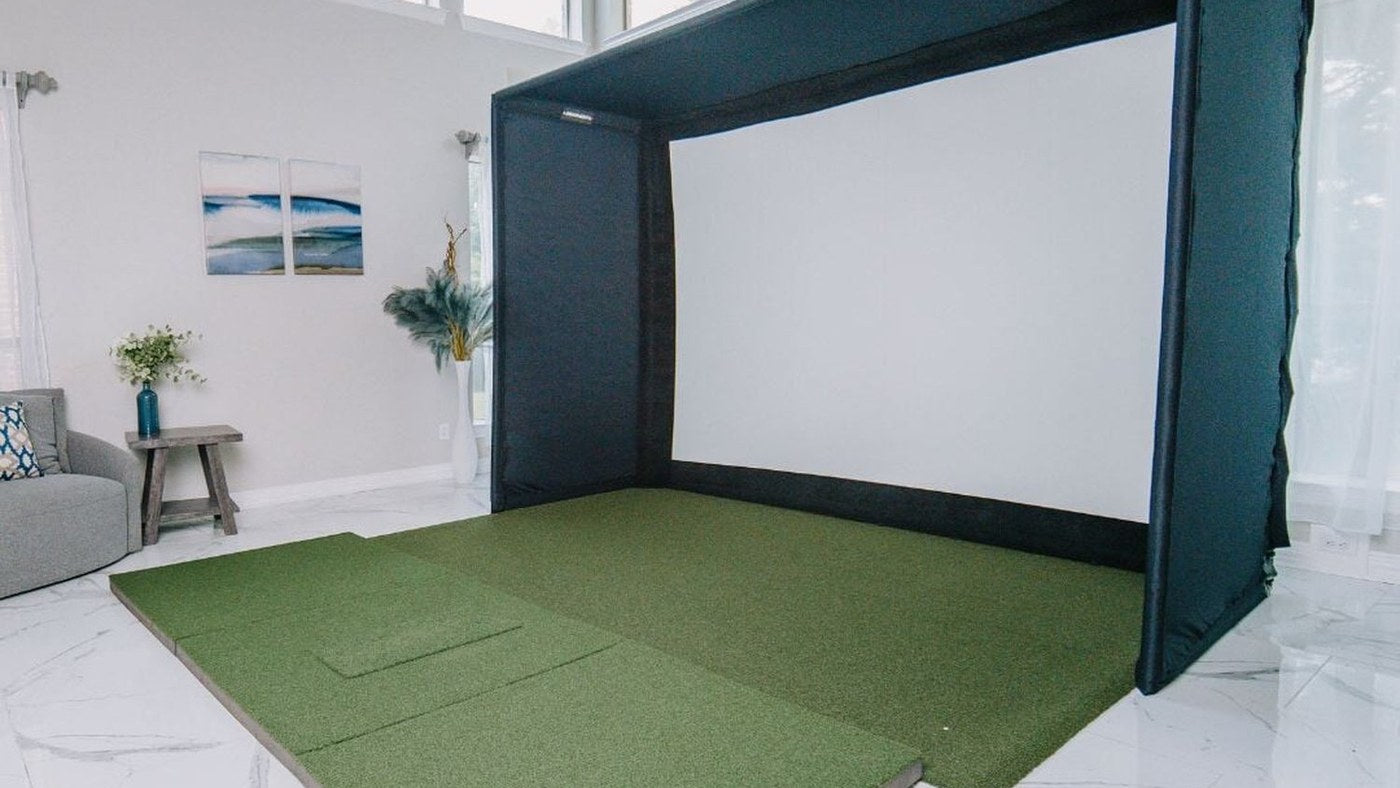 SIG10 enclosure and hitting mat set up in a finished home golf room.