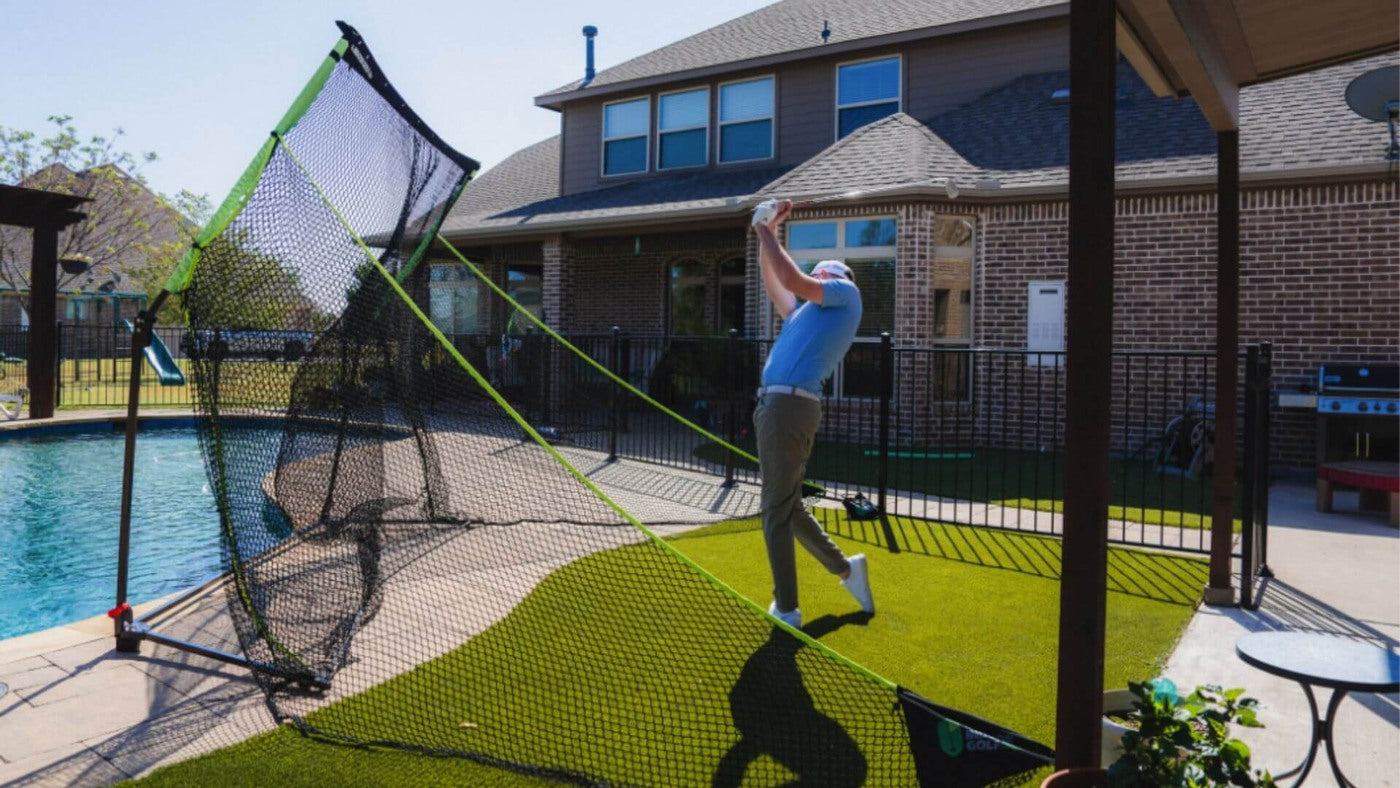 SIGPRO Golf Net set up on a patio with a golfer hitting into the net.