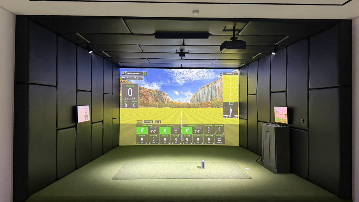 SkyTrak golf simulator room with a ceiling-mounted BenQ projector, padded walls and an impact screen